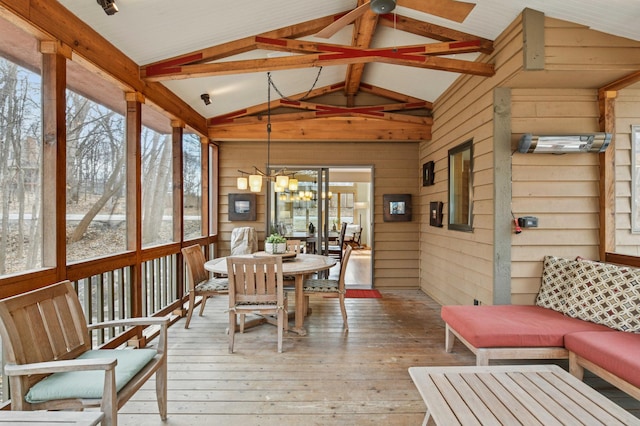 sunroom / solarium featuring a healthy amount of sunlight, beamed ceiling, ceiling fan with notable chandelier, and outdoor dining space
