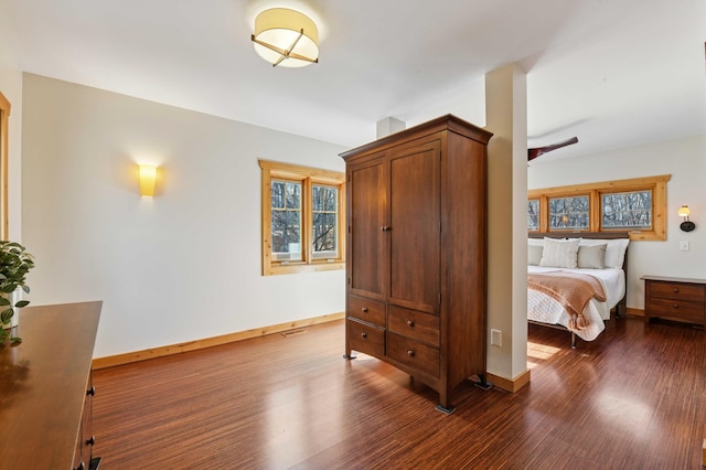 bedroom featuring baseboards and dark wood finished floors