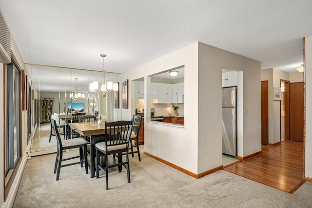 dining area with baseboards, light carpet, a textured ceiling, and a chandelier