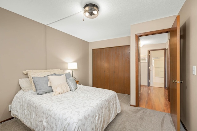 bedroom featuring a closet, light colored carpet, and a textured ceiling