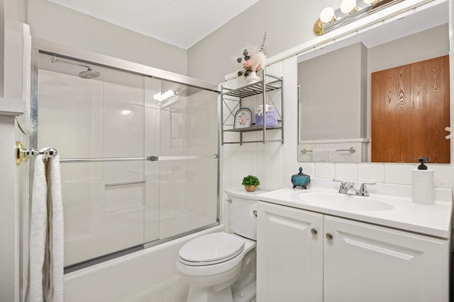 full bathroom with vanity, toilet, and combined bath / shower with glass door