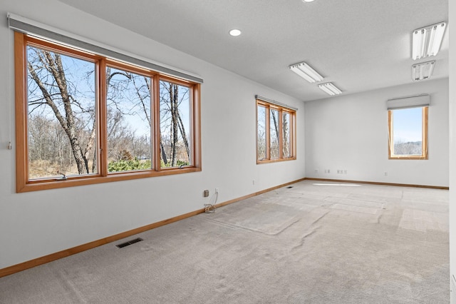 spare room featuring recessed lighting, baseboards, visible vents, and light carpet