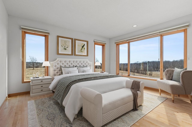 bedroom featuring light wood finished floors, recessed lighting, and baseboards