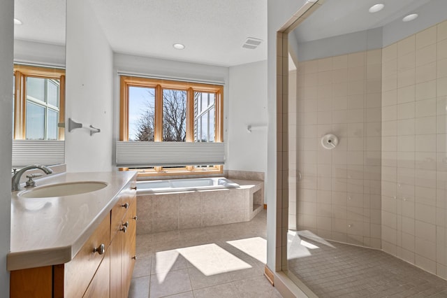 full bathroom featuring tile patterned floors, plenty of natural light, a garden tub, and walk in shower