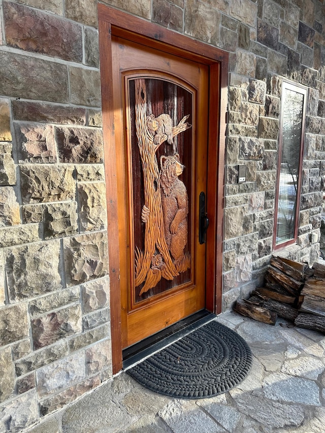 doorway to property featuring stone siding