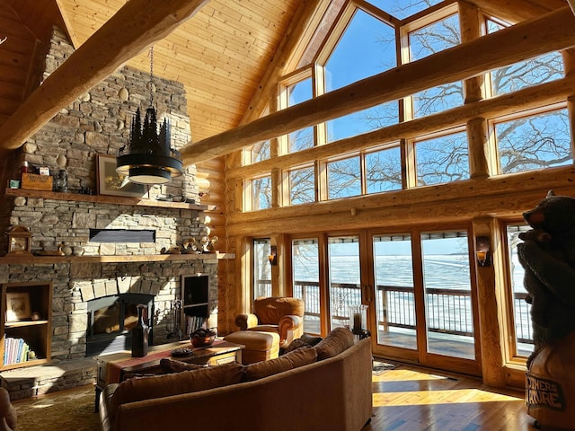 living room featuring a water view, hardwood / wood-style floors, a fireplace, wooden ceiling, and rustic walls