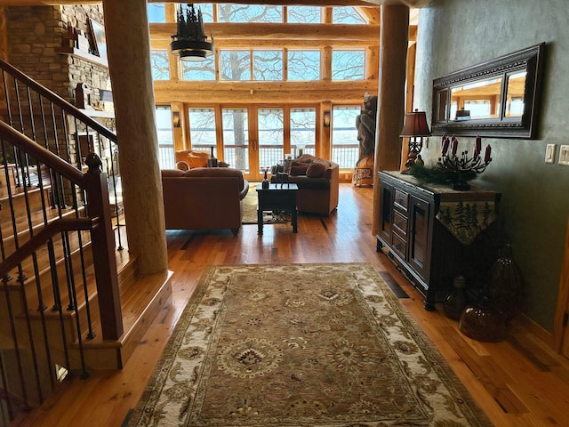 living area featuring stairway, wood-type flooring, and a towering ceiling