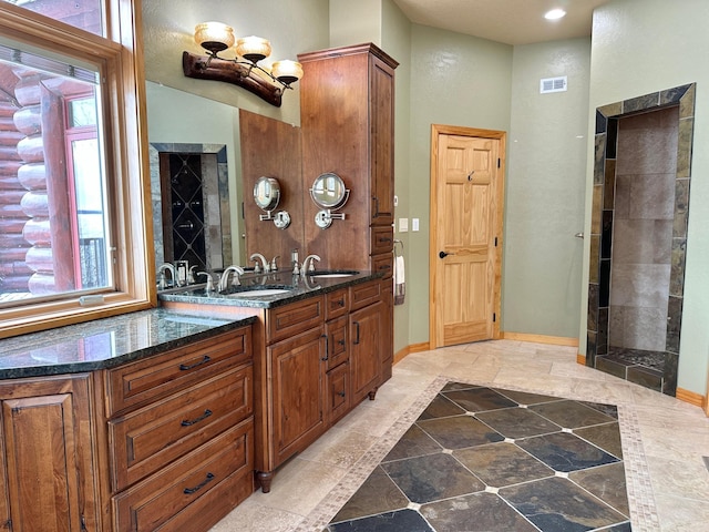 full bath featuring vanity, visible vents, and baseboards