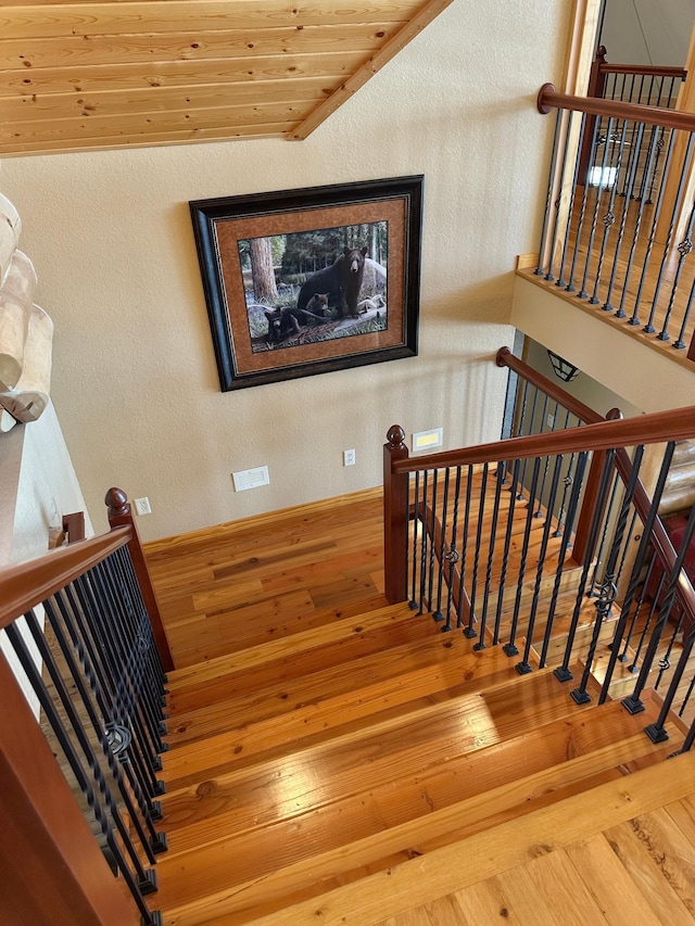 staircase with a textured wall and hardwood / wood-style flooring