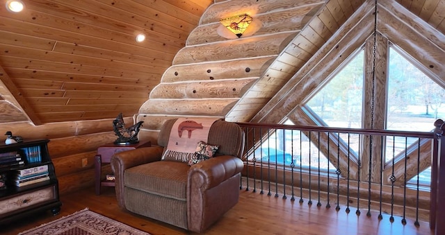 living area featuring lofted ceiling, wood ceiling, wood finished floors, and rustic walls