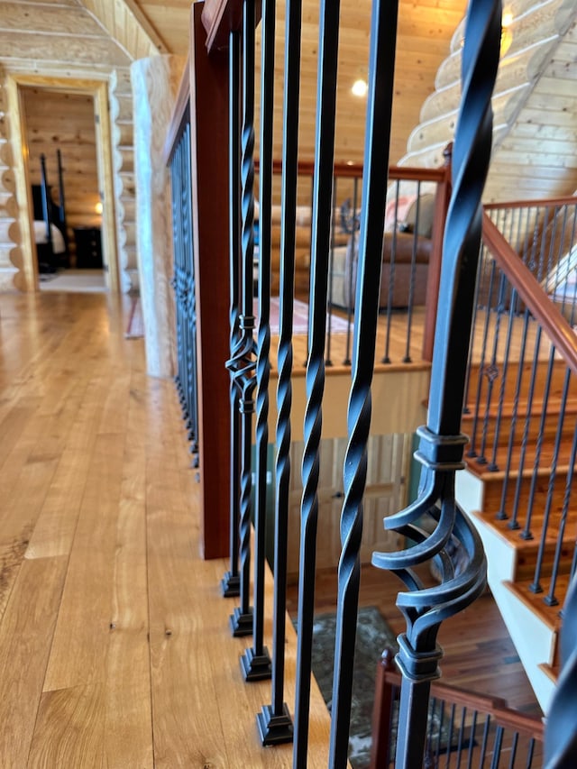 interior space with stairway, wood-type flooring, and log walls