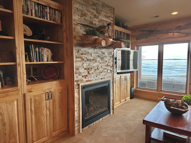 living room with visible vents, carpet, and a fireplace