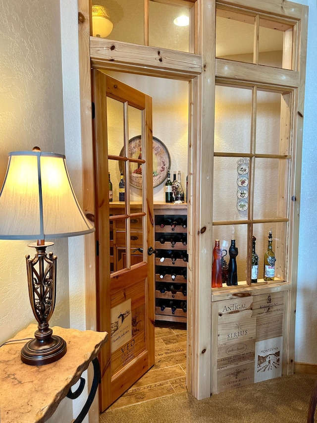 wine room with wood finished floors and a textured wall