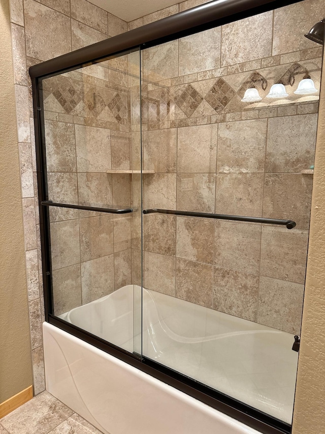 bathroom featuring tile patterned floors and shower / bath combination with glass door