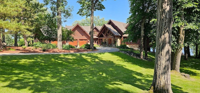 view of front of home featuring stone siding and a front lawn