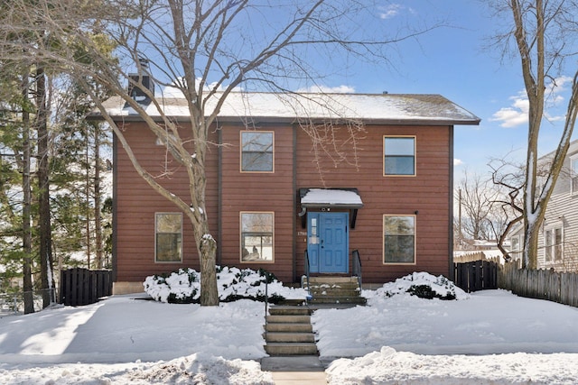 colonial-style house featuring fence