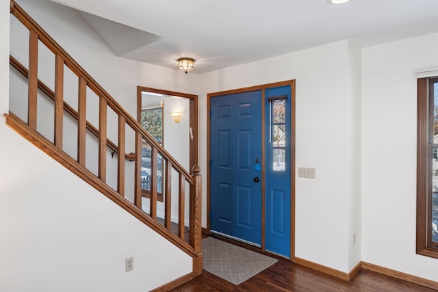 entryway with stairs, dark wood-type flooring, and baseboards