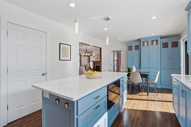 kitchen with blue cabinetry, light wood-style floors, and light countertops