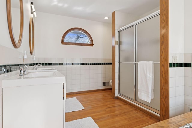 full bathroom featuring toilet, wood finished floors, tile walls, a shower stall, and vanity