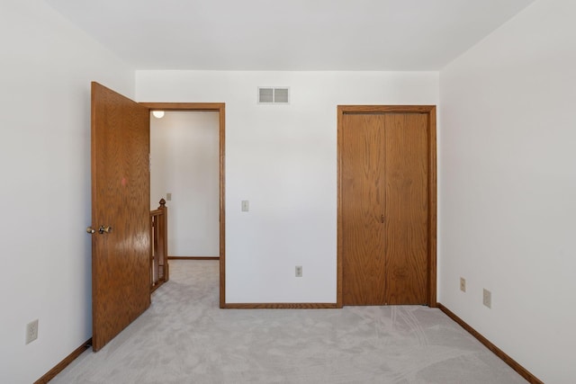 bedroom featuring visible vents, baseboards, light colored carpet, and a closet