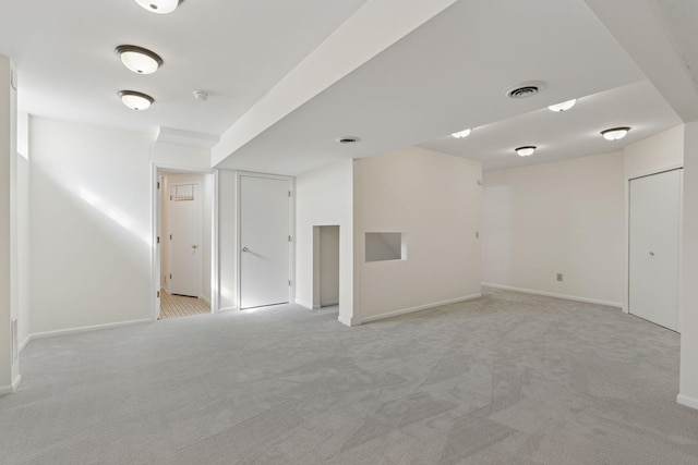 empty room with visible vents, light colored carpet, and baseboards