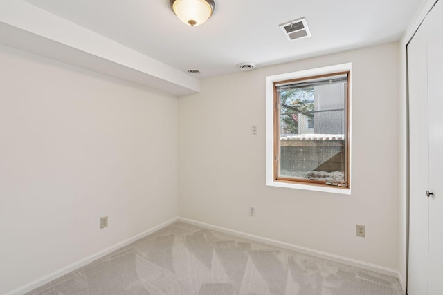 empty room featuring visible vents, light colored carpet, and baseboards