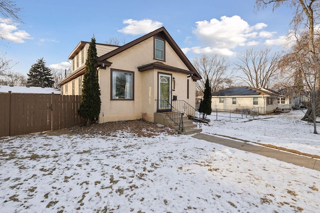 bungalow-style home with fence and stucco siding