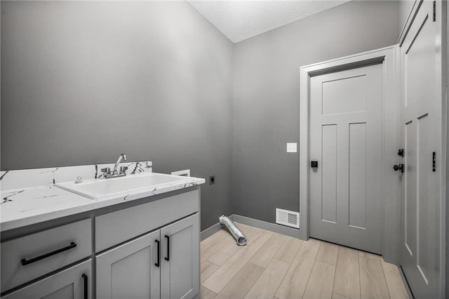 bathroom with vanity, hardwood / wood-style floors, and a textured ceiling