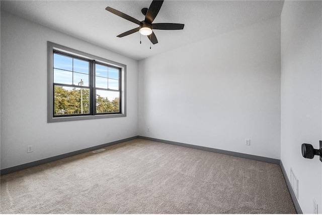 empty room with ceiling fan, a textured ceiling, and carpet