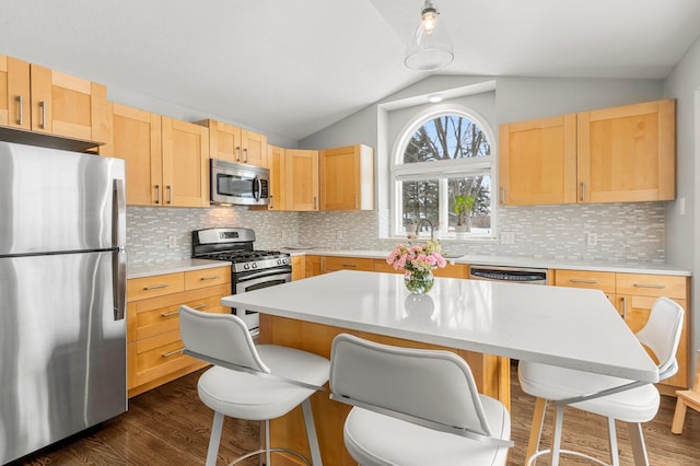 kitchen with sink, stainless steel appliances, a center island, and light brown cabinets