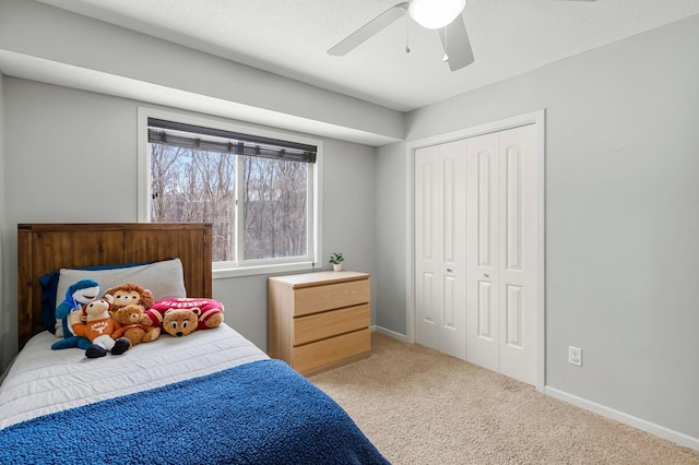 bedroom featuring ceiling fan, a closet, and light carpet