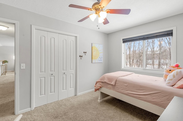 carpeted bedroom featuring a textured ceiling, ceiling fan, and a closet