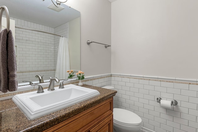 bathroom with vanity, curtained shower, tile walls, and toilet