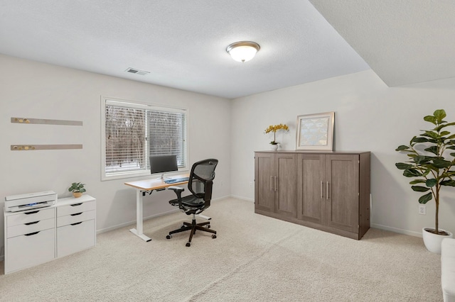 carpeted home office featuring a textured ceiling