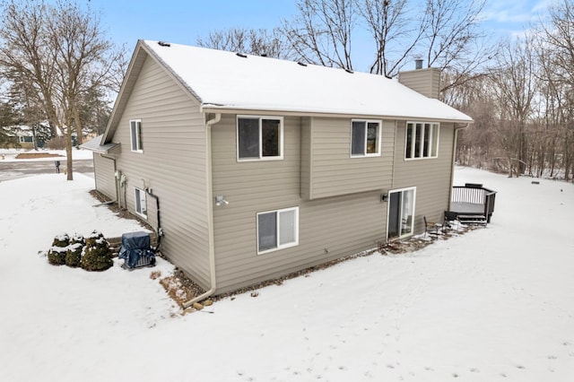 snow covered property with a deck