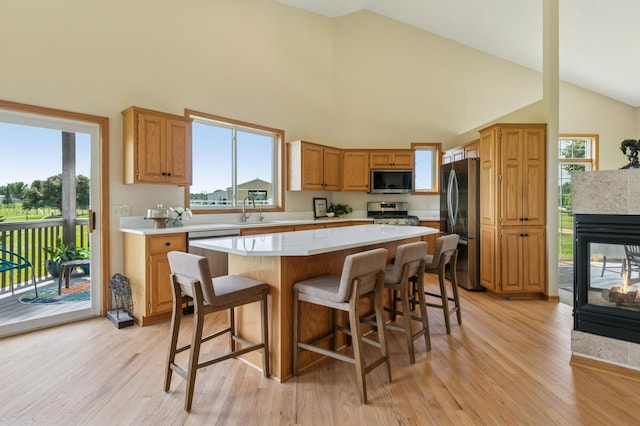 8051 165th St E, Credit River Twp, MN 55372 - kitchen featuring appliances with stainless steel finishes, light countertops, high vaulted ceiling, light wood finished floors, and a kitchen island