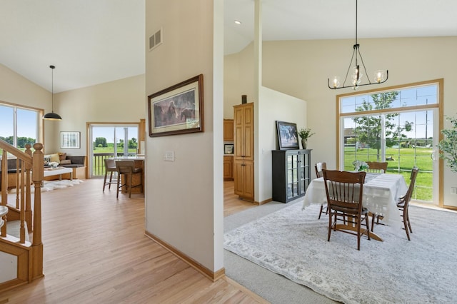 8051 165th St E, Credit River Twp, MN 55372 - dining space featuring high vaulted ceiling, light wood-style flooring, healthy amount of natural light, and a chandelier