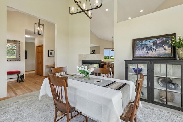 8051 165th St E, Credit River Twp, MN 55372 - dining room with a chandelier, high vaulted ceiling, wood finished floors, a tile fireplace, and recessed lighting