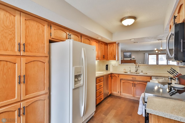 kitchen featuring sink, backsplash, stainless steel appliances, dark hardwood / wood-style flooring, and a chandelier