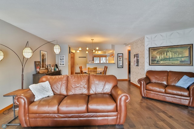 living room featuring a notable chandelier, a textured ceiling, and dark hardwood / wood-style flooring