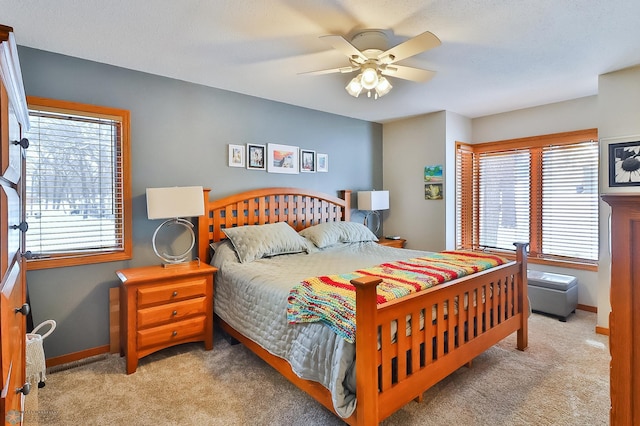 carpeted bedroom with ceiling fan and multiple windows