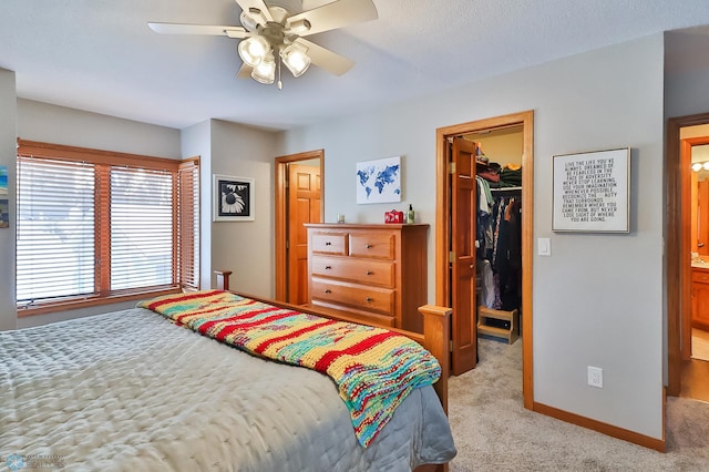 bedroom featuring ceiling fan, light colored carpet, a spacious closet, and a closet