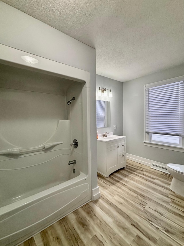 full bathroom featuring hardwood / wood-style flooring, vanity, a textured ceiling, shower / bathtub combination, and toilet