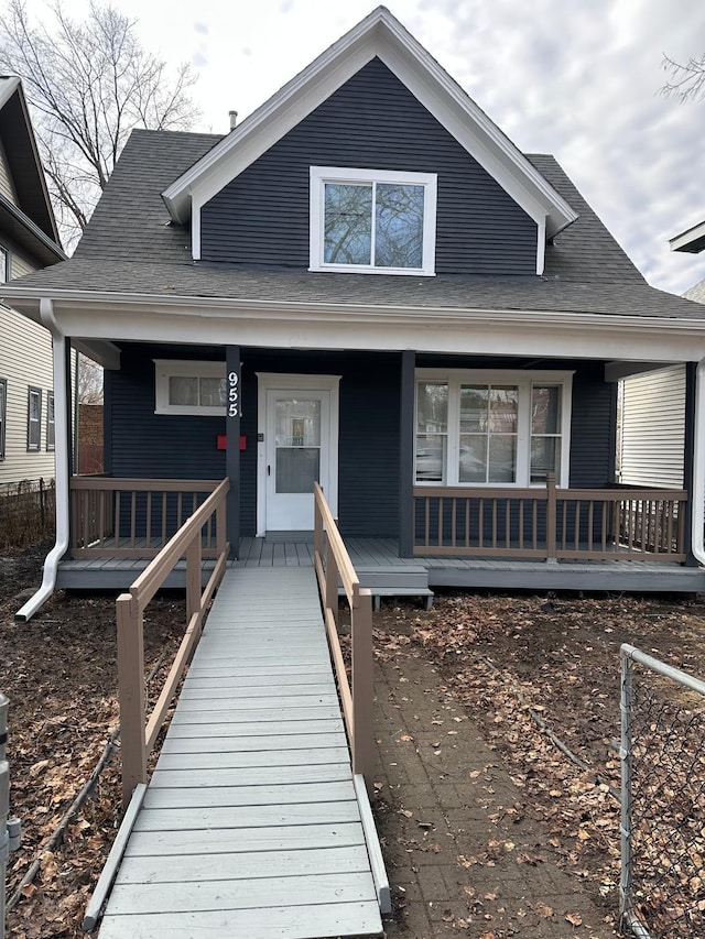 bungalow featuring a porch and roof with shingles