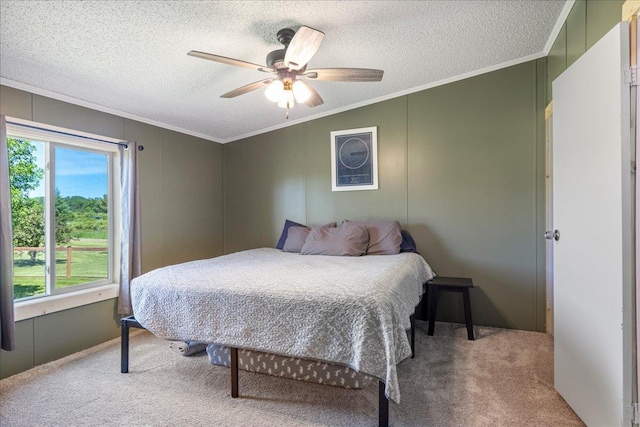 bedroom featuring a ceiling fan, carpet, crown molding, and a textured ceiling