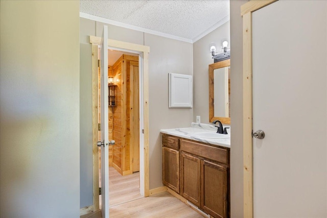 bathroom featuring vanity, crown molding, wood finished floors, and a textured ceiling