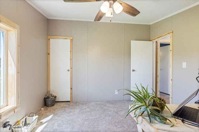 interior space featuring carpet flooring, crown molding, and a ceiling fan