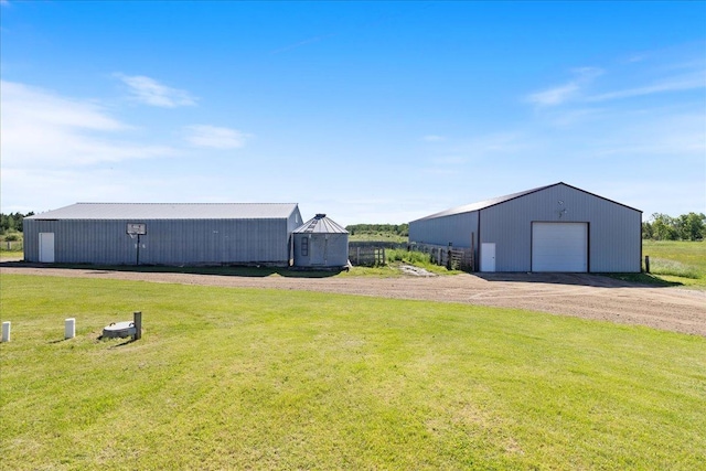 view of yard with an outbuilding, a garage, and dirt driveway