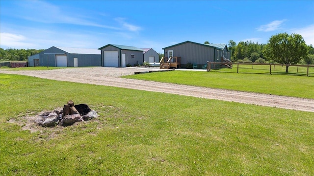 view of yard with a detached garage, an outdoor structure, and fence