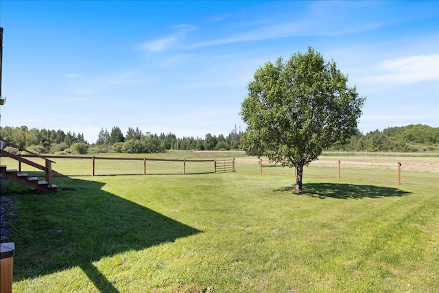 view of yard with a rural view and fence